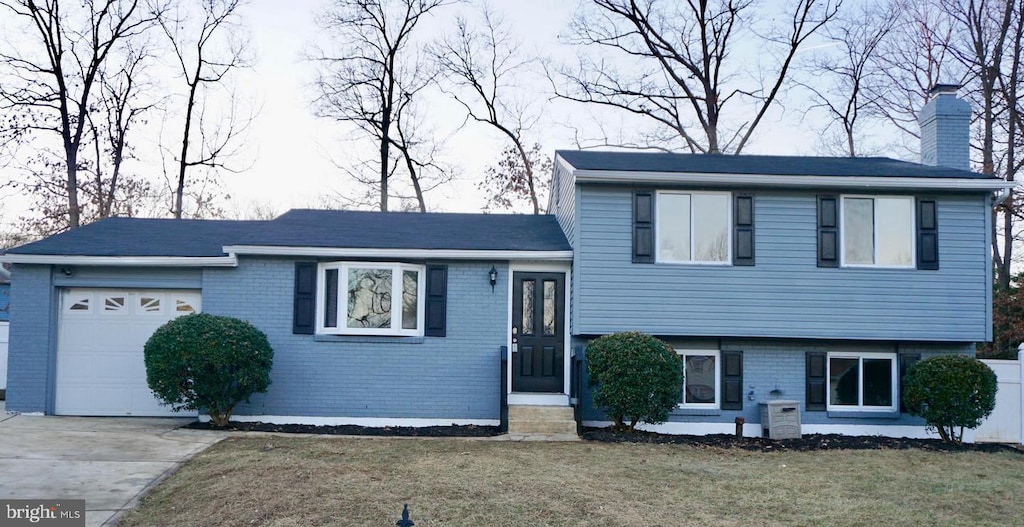 tri-level home with a garage and a front yard