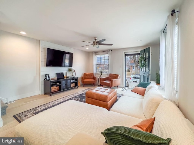 living room with ceiling fan and light hardwood / wood-style flooring