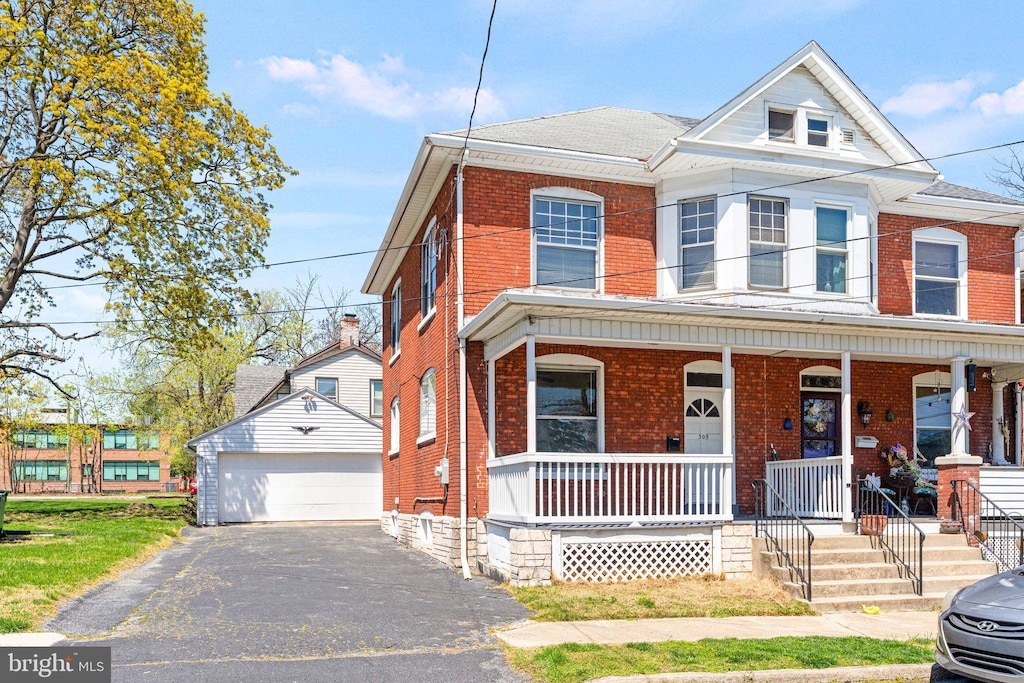 305 11th St, New Cumberland, PA 17070 - view of property with a detached garage, covered porch, an outbuilding, brick siding, and roof with shingles
