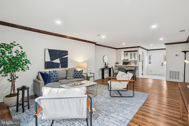 living room with visible vents, baseboards, and wood finished floors