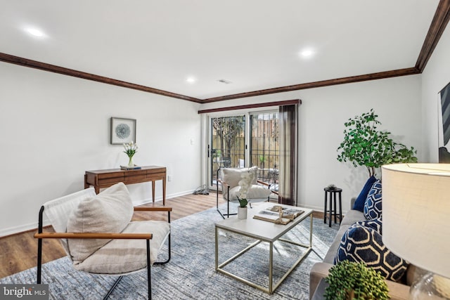 living area featuring crown molding, baseboards, and wood finished floors