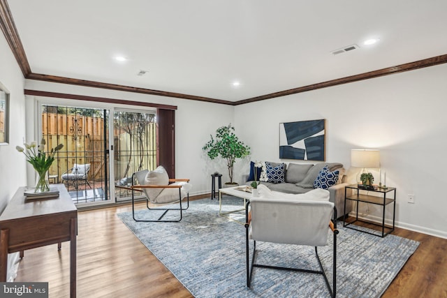 living area with recessed lighting, wood finished floors, visible vents, baseboards, and ornamental molding