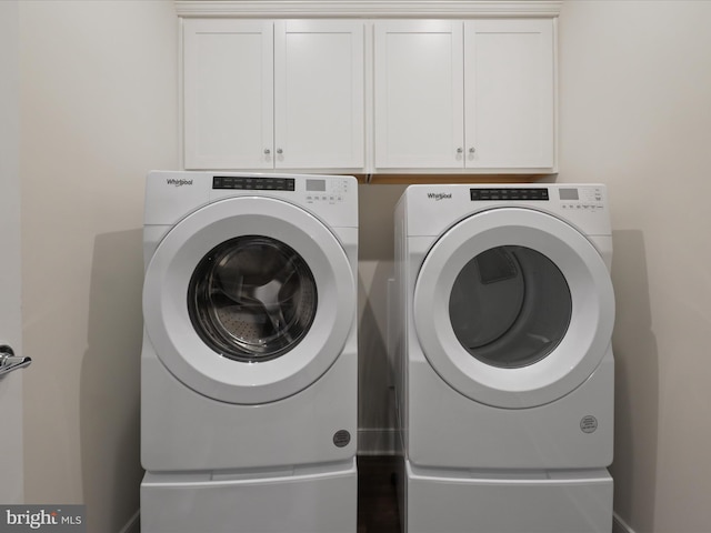 washroom featuring cabinets and washing machine and clothes dryer