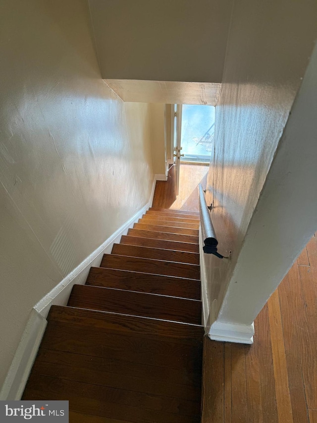 stairway with baseboards and wood finished floors