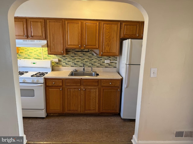 kitchen with visible vents, light countertops, a sink, white appliances, and under cabinet range hood