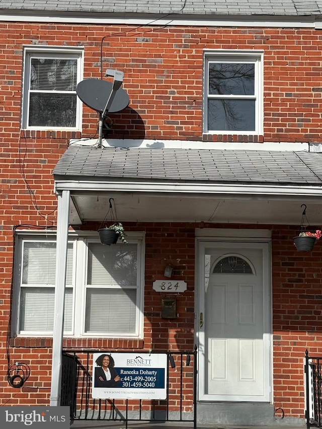 doorway to property featuring brick siding