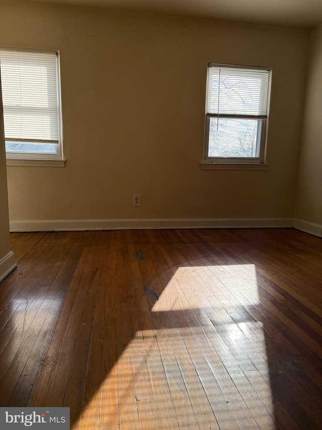 empty room with dark wood-style floors and a healthy amount of sunlight