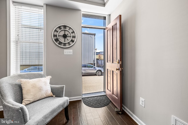 foyer with dark wood-type flooring and a wall of windows