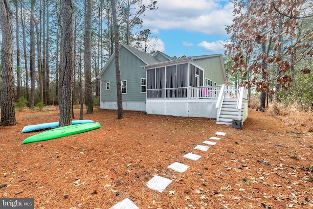 back of property with stairway and a sunroom