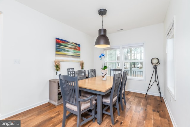 dining area featuring wood-type flooring and baseboards