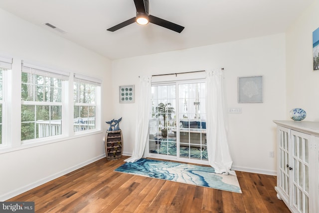 living area featuring a wealth of natural light, visible vents, and hardwood / wood-style floors