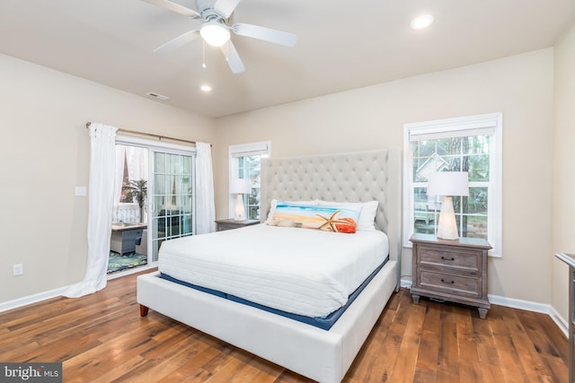 bedroom featuring access to outside, hardwood / wood-style floors, visible vents, and baseboards