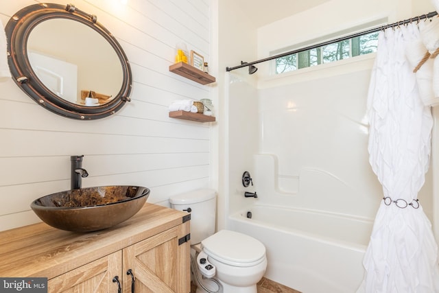 bathroom featuring shower / bathtub combination with curtain, toilet, and vanity