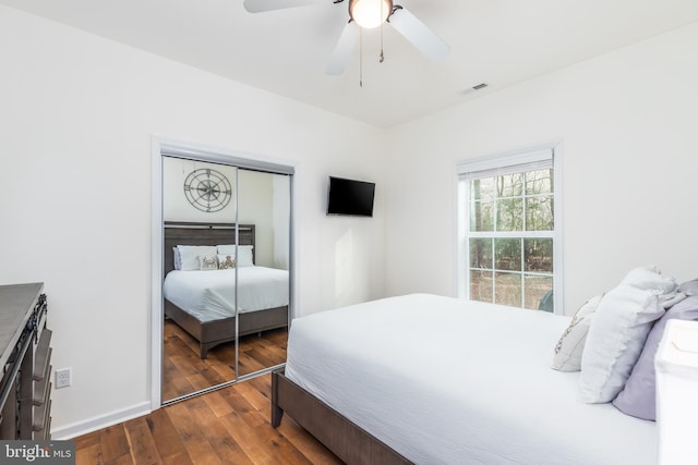 bedroom featuring ceiling fan, visible vents, baseboards, a closet, and dark wood finished floors