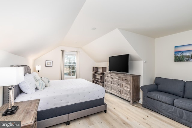 bedroom featuring vaulted ceiling and light wood-style flooring