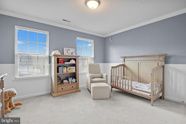 carpeted bedroom with ornamental molding, a nursery area, visible vents, and baseboards