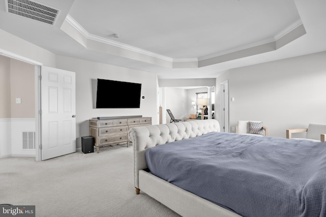 carpeted bedroom featuring a tray ceiling, visible vents, and crown molding