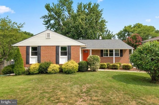 view of front of house featuring a front yard, brick siding, and fence