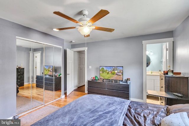 bedroom with connected bathroom, baseboards, a closet, and wood finished floors