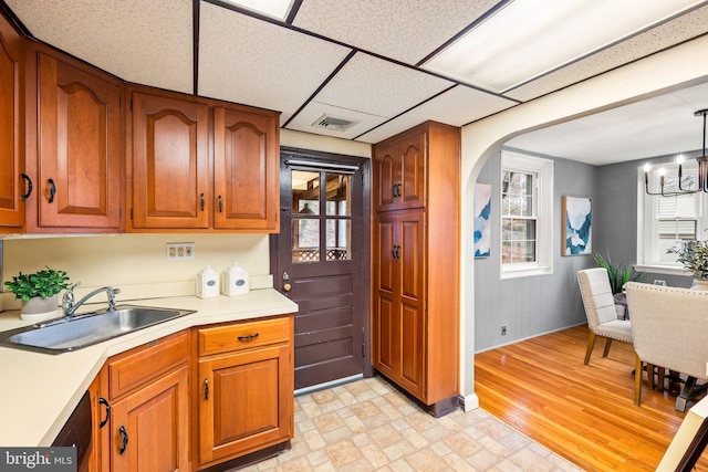 kitchen with light countertops, a sink, and brown cabinets