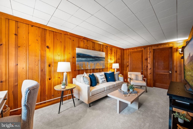 living area with carpet and wooden walls