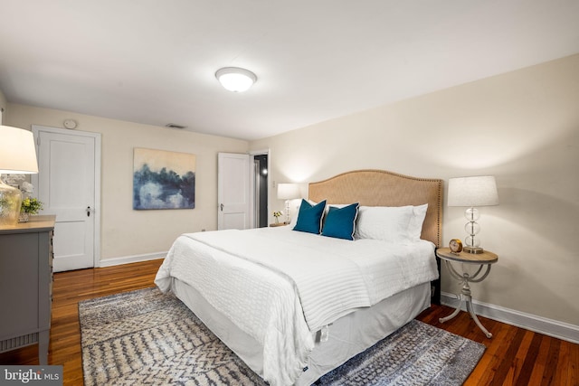 bedroom with wood finished floors, visible vents, and baseboards