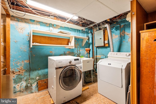 clothes washing area featuring a sink, laundry area, washing machine and clothes dryer, and electric panel