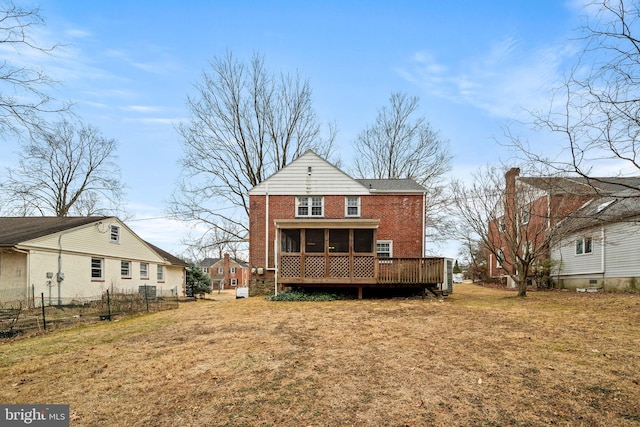 rear view of property with a sunroom, fence, a lawn, and brick siding