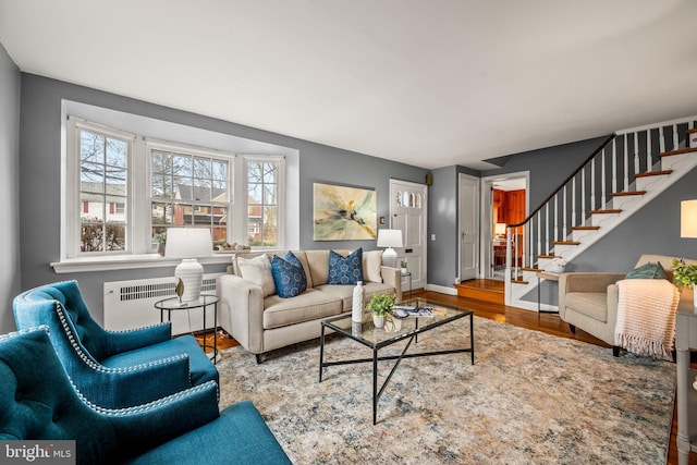 living room with baseboards, stairway, wood finished floors, and radiator