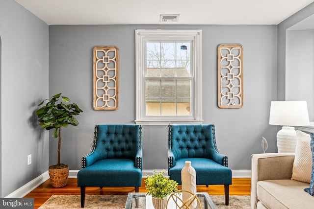 sitting room featuring visible vents, baseboards, and wood finished floors