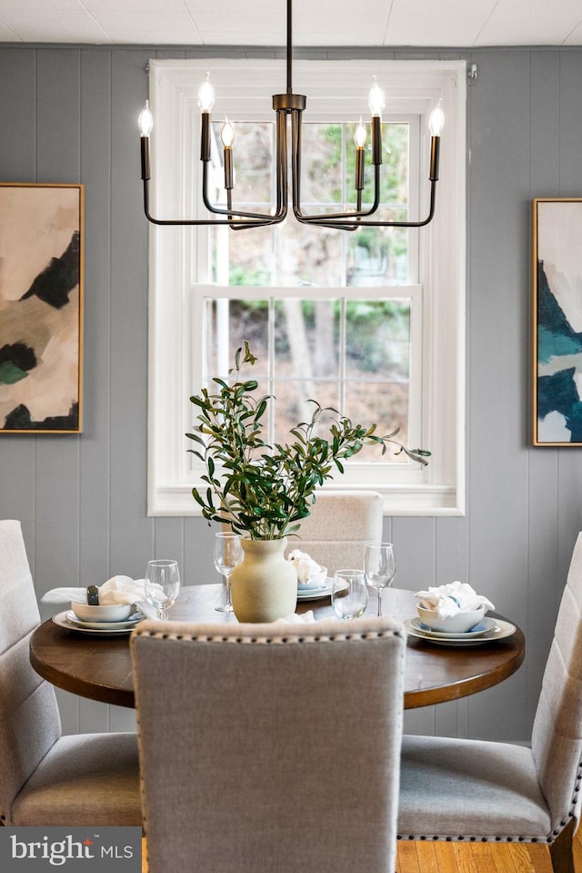 dining area featuring a chandelier and a decorative wall