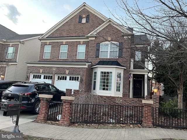 view of front facade featuring a garage, concrete driveway, brick siding, and a fenced front yard