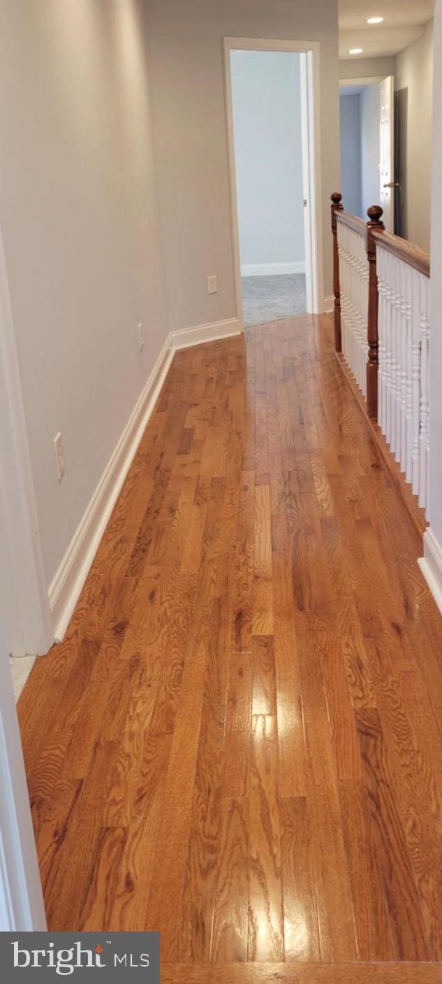 spare room featuring baseboards and wood finished floors