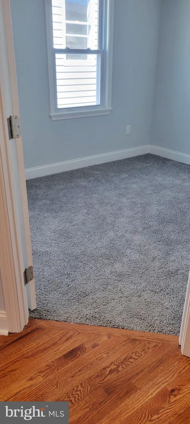 carpeted spare room featuring baseboards