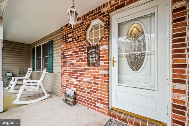 doorway to property featuring brick siding