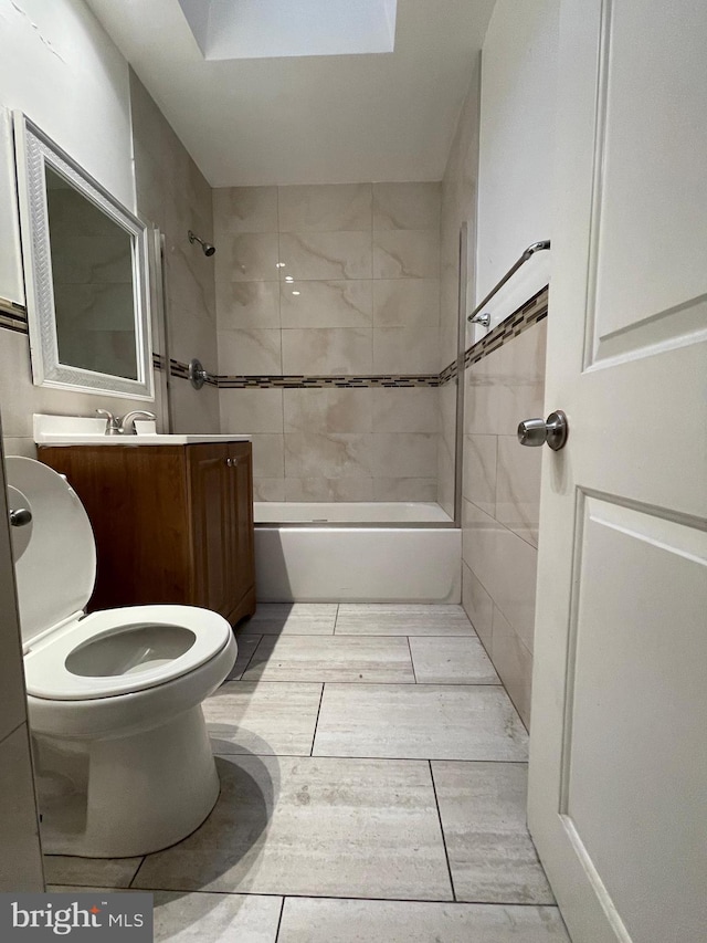 full bathroom with vanity, tiled shower / bath, and toilet