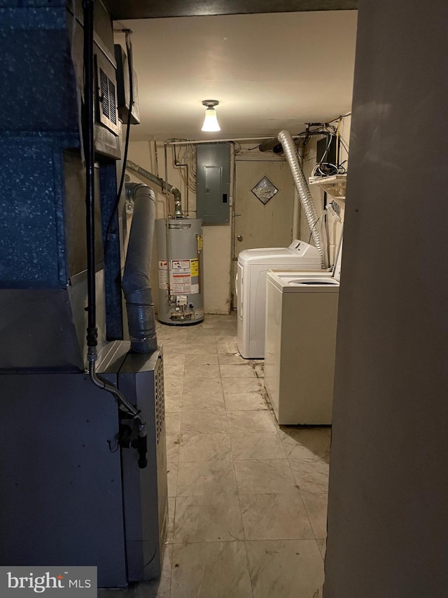 clothes washing area featuring gas water heater, electric panel, and washing machine and clothes dryer