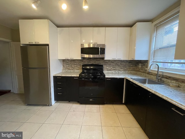 kitchen featuring white cabinetry, sink, stainless steel appliances, and light tile patterned flooring