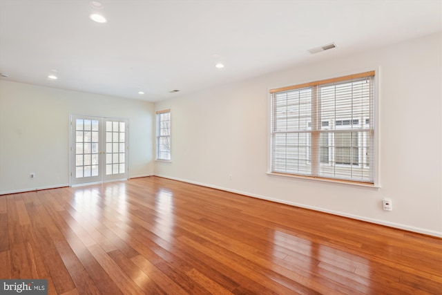 unfurnished room featuring french doors and light hardwood / wood-style floors