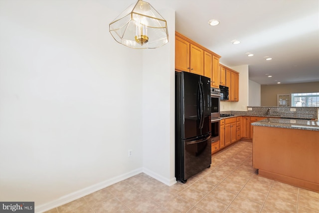 kitchen featuring decorative light fixtures, black appliances, dark stone countertops, light tile patterned floors, and kitchen peninsula