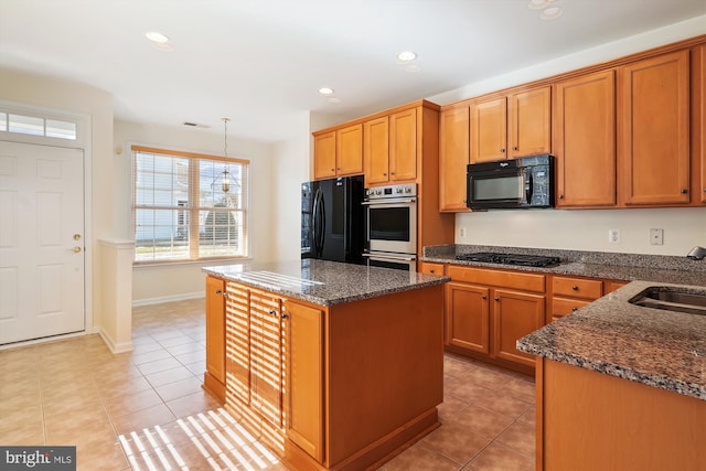 kitchen featuring light tile patterned flooring, a kitchen island, sink, dark stone counters, and black appliances