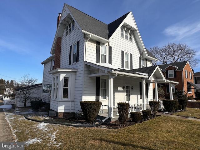 view of front of house with a front yard and a porch