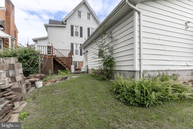 exterior space with a wooden deck and a lawn