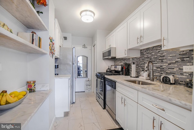 kitchen with tasteful backsplash, stainless steel appliances, light stone counters, white cabinets, and sink