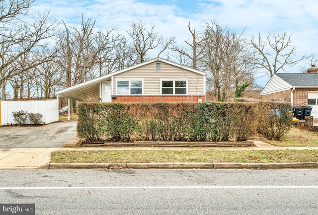 view of front of home featuring a carport, brick siding, and driveway