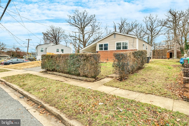 view of side of home with a lawn and brick siding