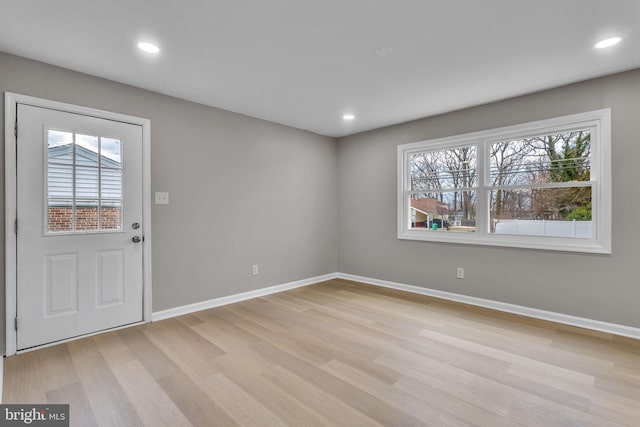 entrance foyer with plenty of natural light, light wood-style flooring, and baseboards