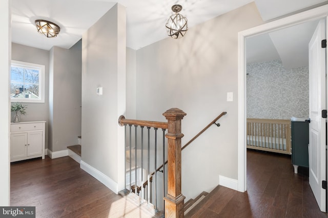 stairway with hardwood / wood-style flooring and a chandelier