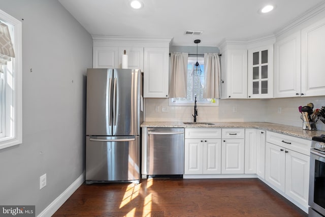 kitchen featuring hanging light fixtures, sink, light stone counters, appliances with stainless steel finishes, and white cabinets