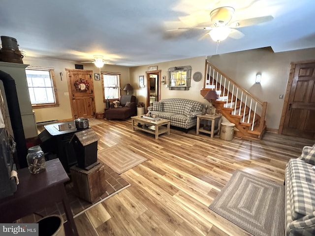 living room with hardwood / wood-style floors, ceiling fan, and baseboard heating